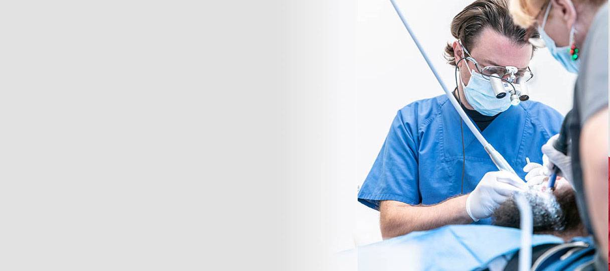 Patient wird vom Zahnarzt oralchirurgisch behandelt